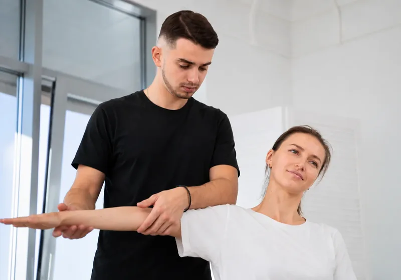 Physical therapist guiding a patient through a hands-on treatment session