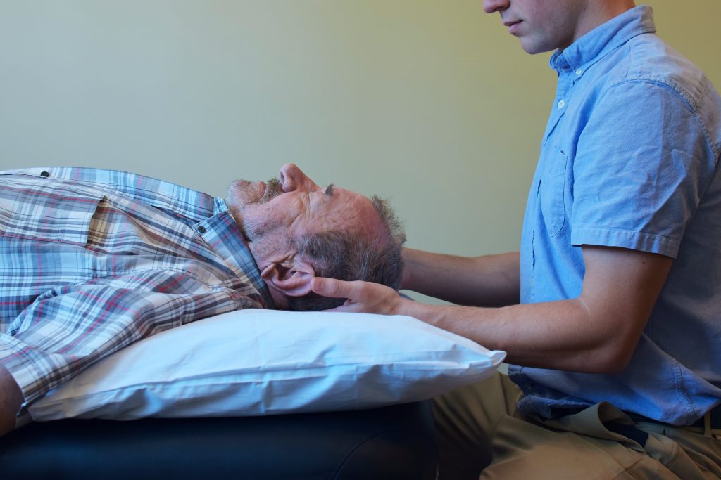 Physical Therapist performing manual assessment of patient's cervical spine